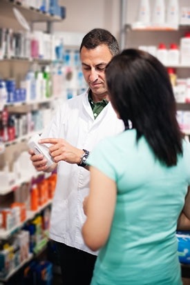 Photo of a pharmacist helping a woman find medication