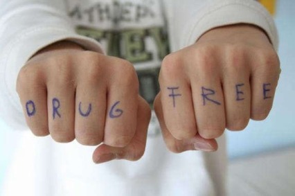 Photo of a person's fists with the words "drug free" written across the fingers.