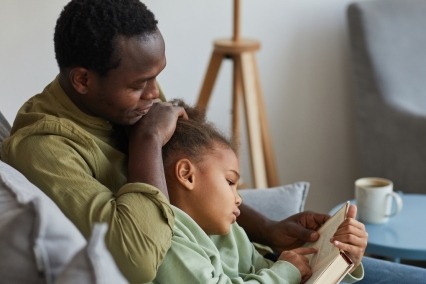 Father reading with young daughter.