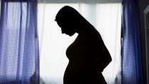 Silhouette of pregnant woman in her bedroom
