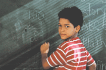 Un niño practicando la matemática en el pizarrón.